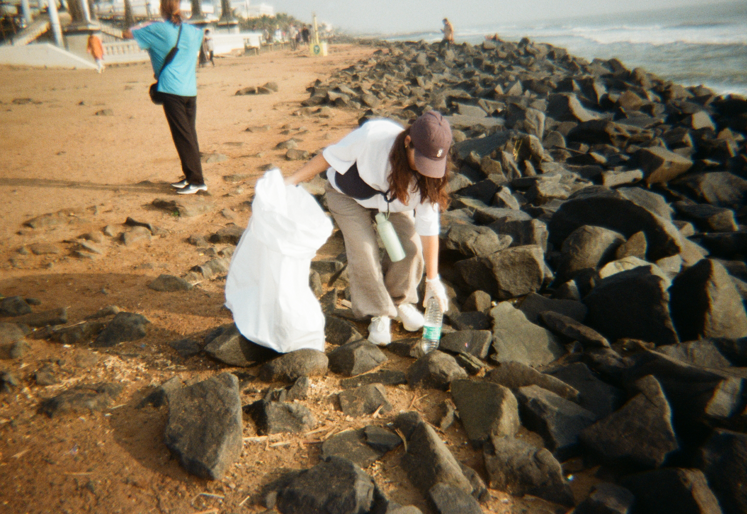 Woman picking up ocean plastic
